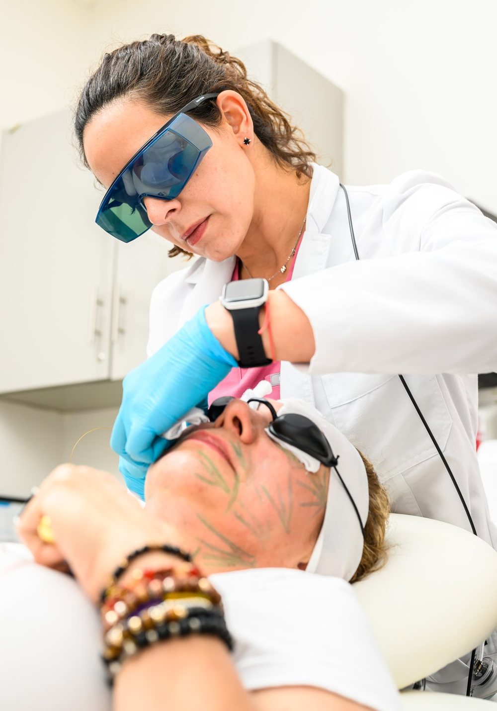 A provider in protective glasses performs a laser treatment